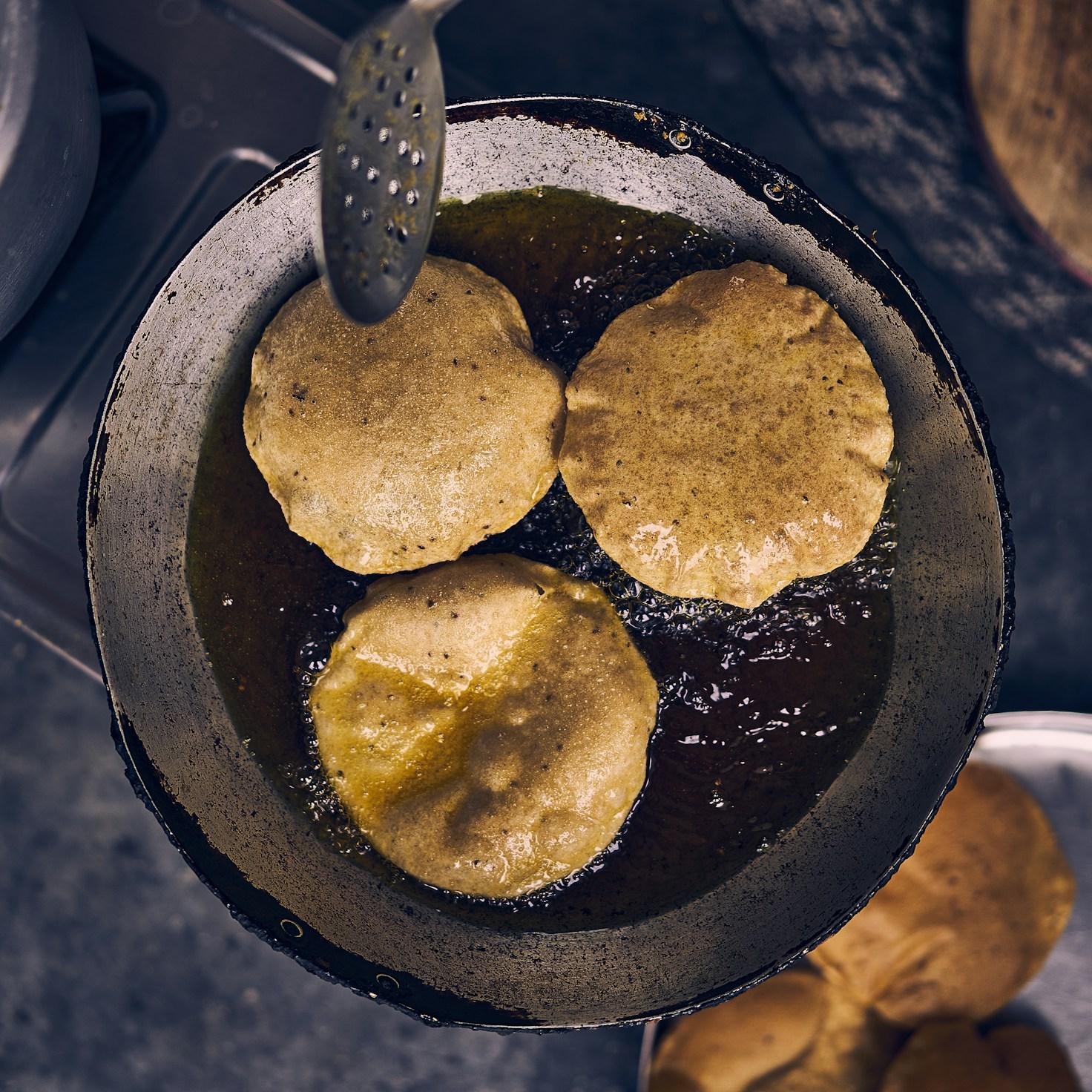 People collaborating in a contemporary kitchen, exchanging recipes and cooking techniques